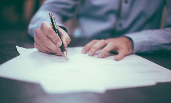 Image of a man signing a document