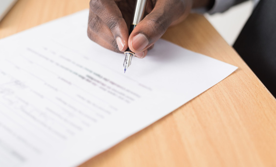 Image of a person signing a document