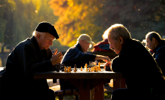 Image of two LGBT elders playing a game of chess