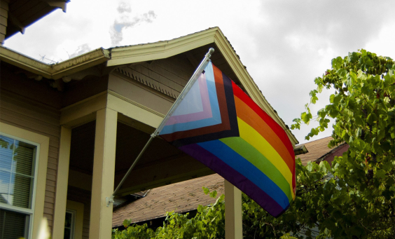 The LGBT flag hanging in front of a house
