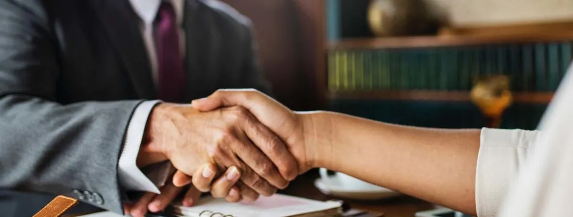 A man's hand and a woman's hand shaking.