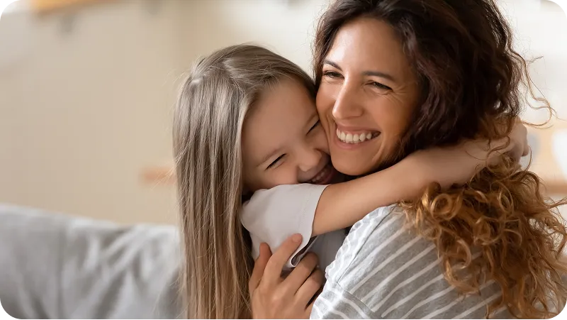 A happy mother embracing her daughter.