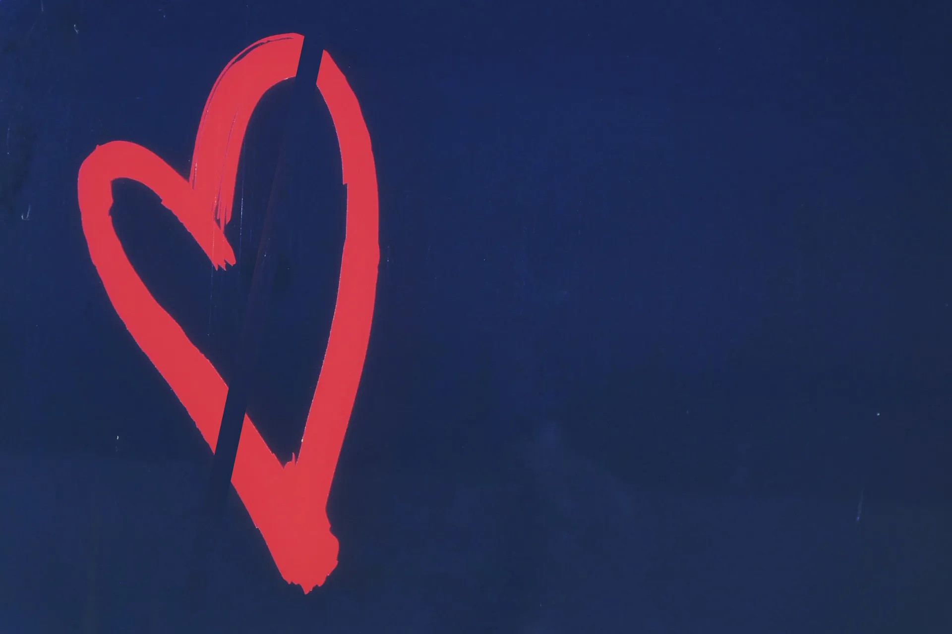 A design of a heart or a broken heart on a dark background.