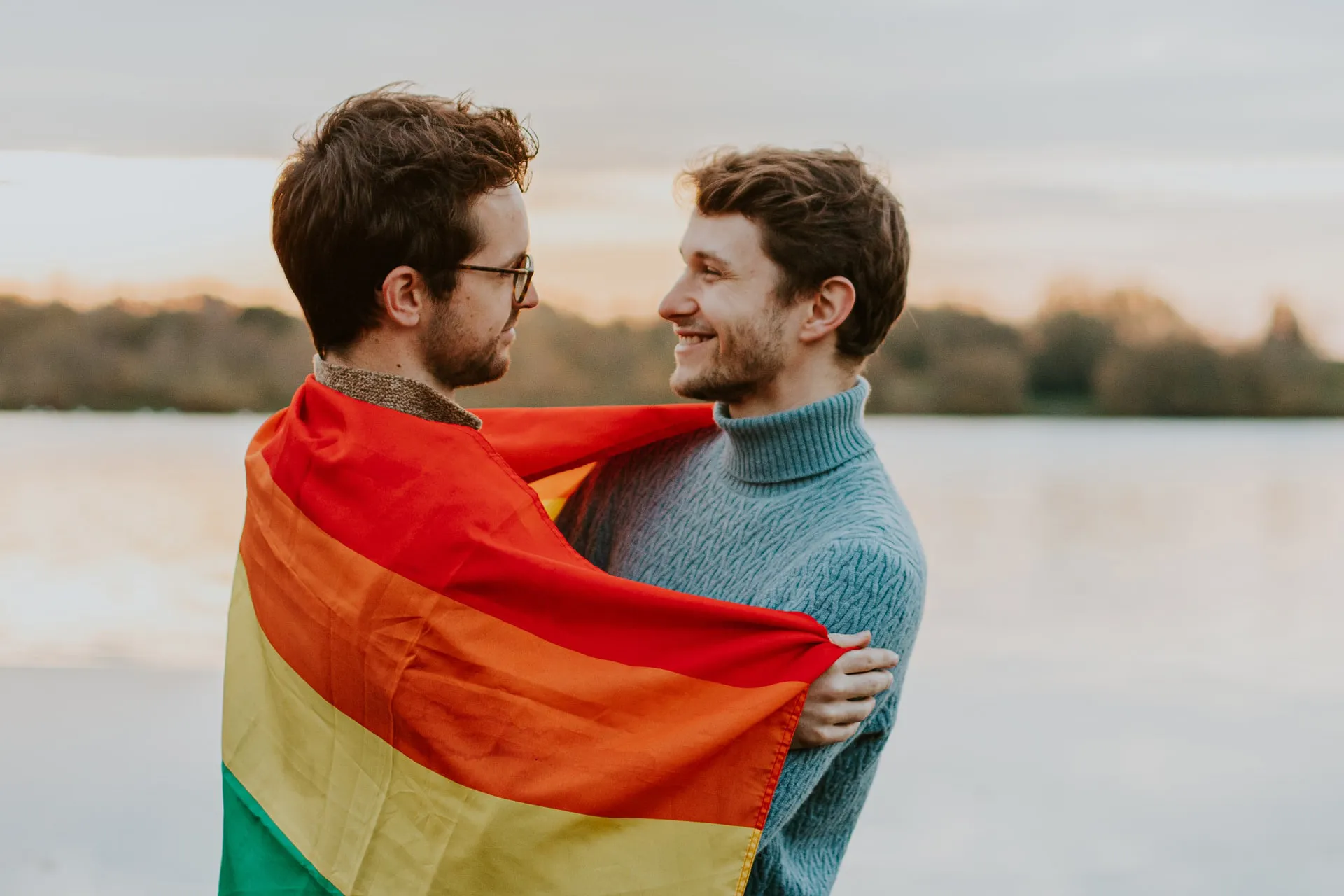 Two men hugging each other and sharing sweet smiles.
