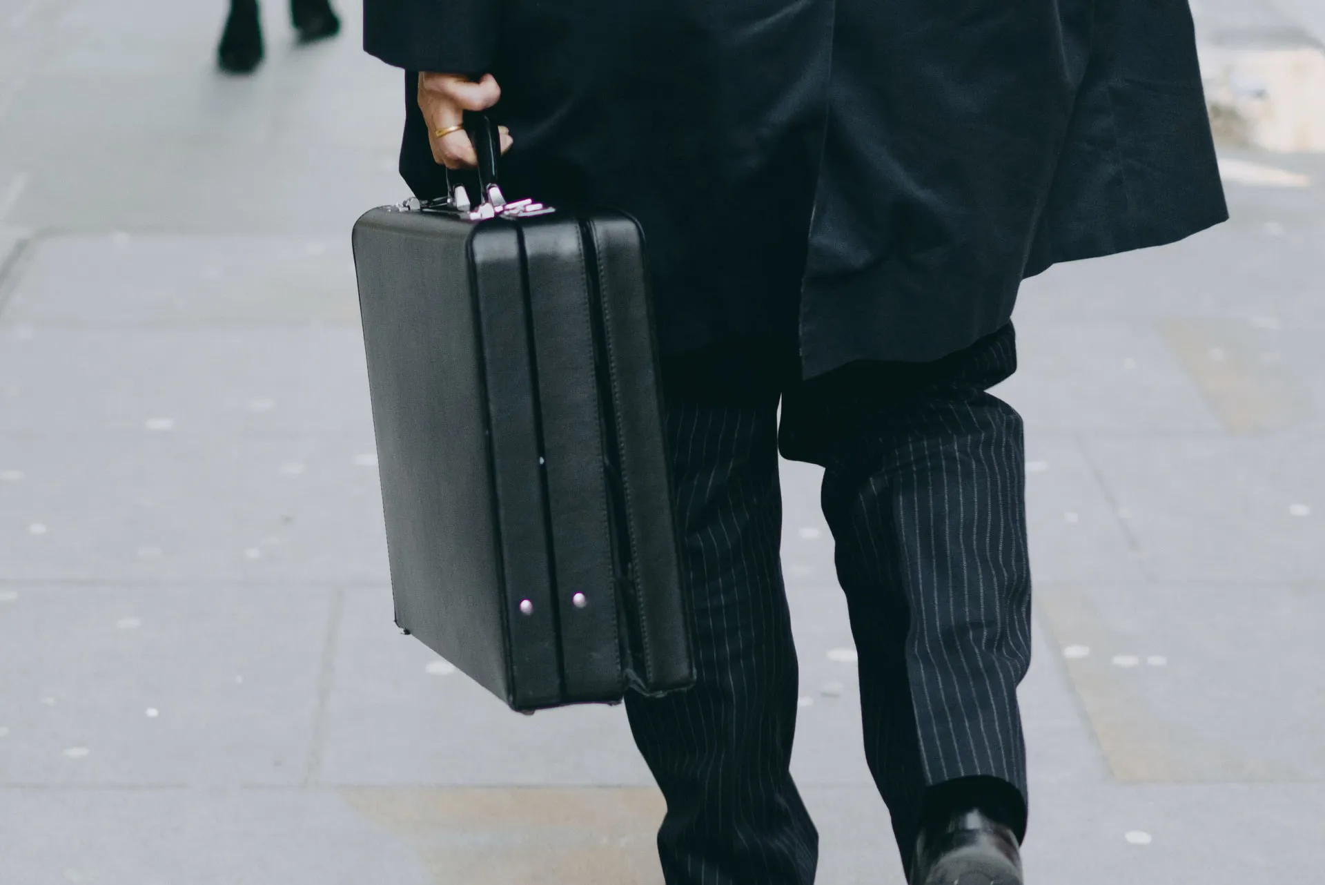 A man walking holding briefcase.