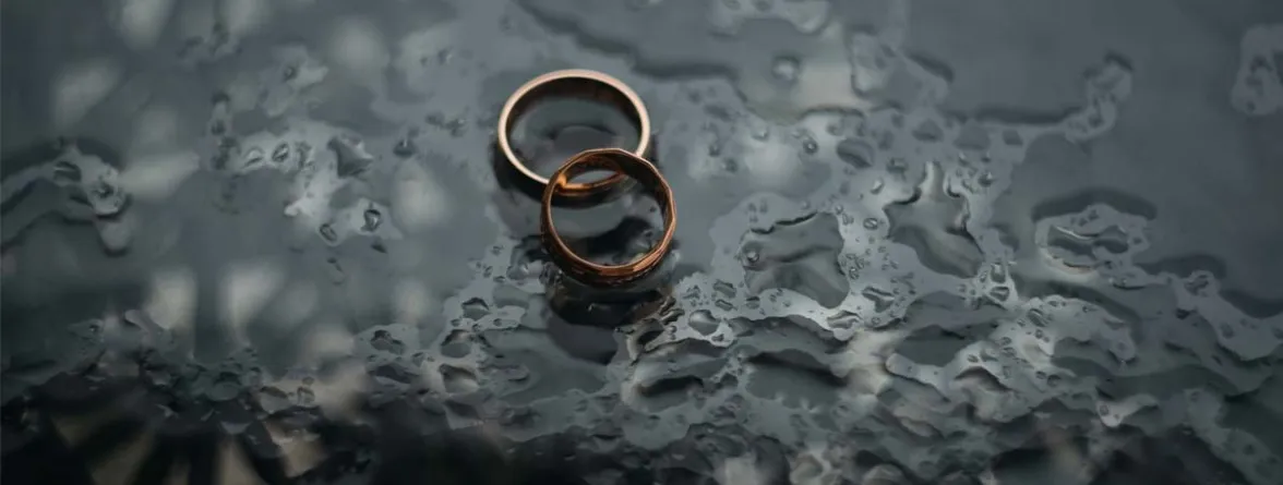 A couple’s rings placed on a glass table.